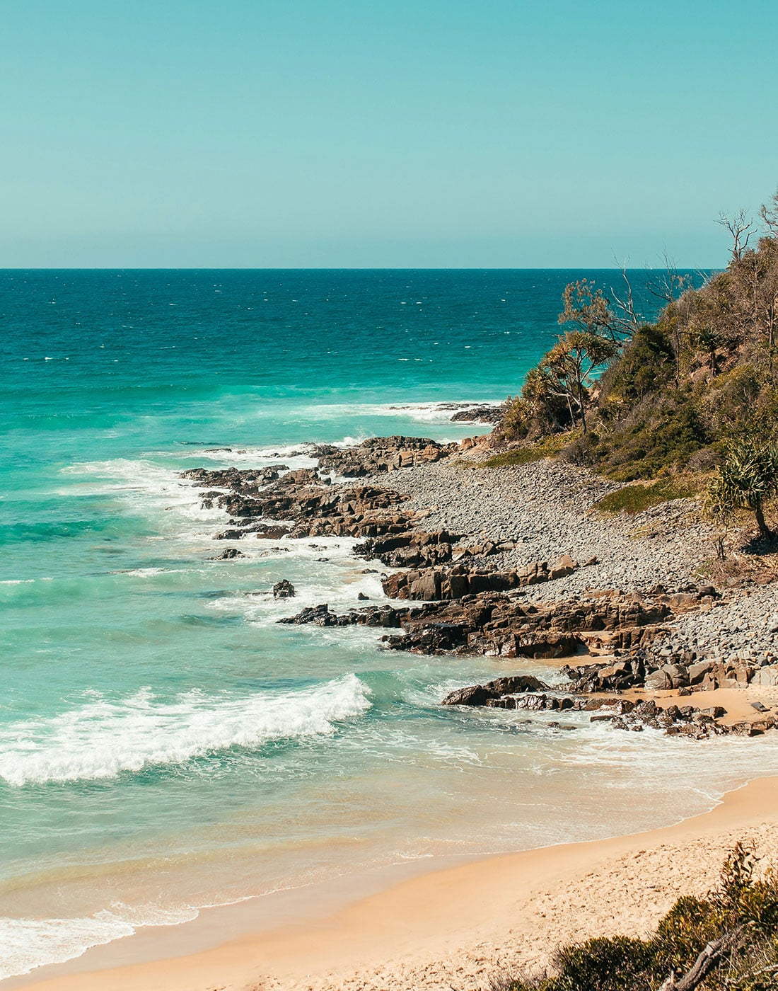 Scenic rocky headland and clear turquoise reef waters at Horseshoe Bay in Bowen.