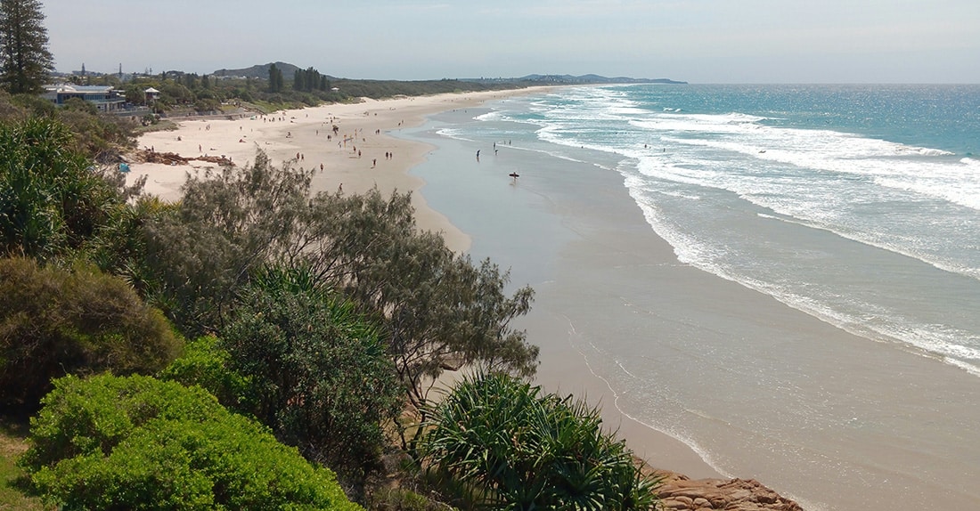 Expansive sandy shoreline and gentle ocean waves at Queens Beach in Bowen near the Whitsundays.