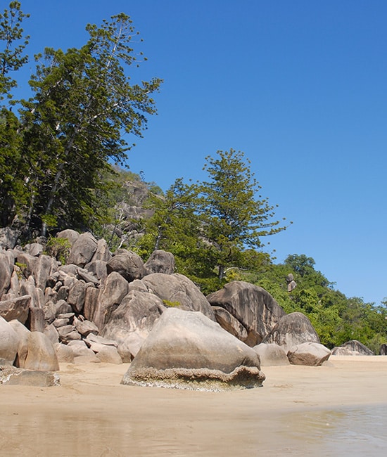 Massive coastal rock formations and green headlands near Cape Gloucester Resort.