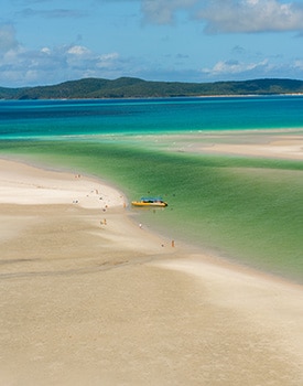 Day trip tour boat anchored on the shore of Whitehaven Beach during a Whitsundays tropical island excursion